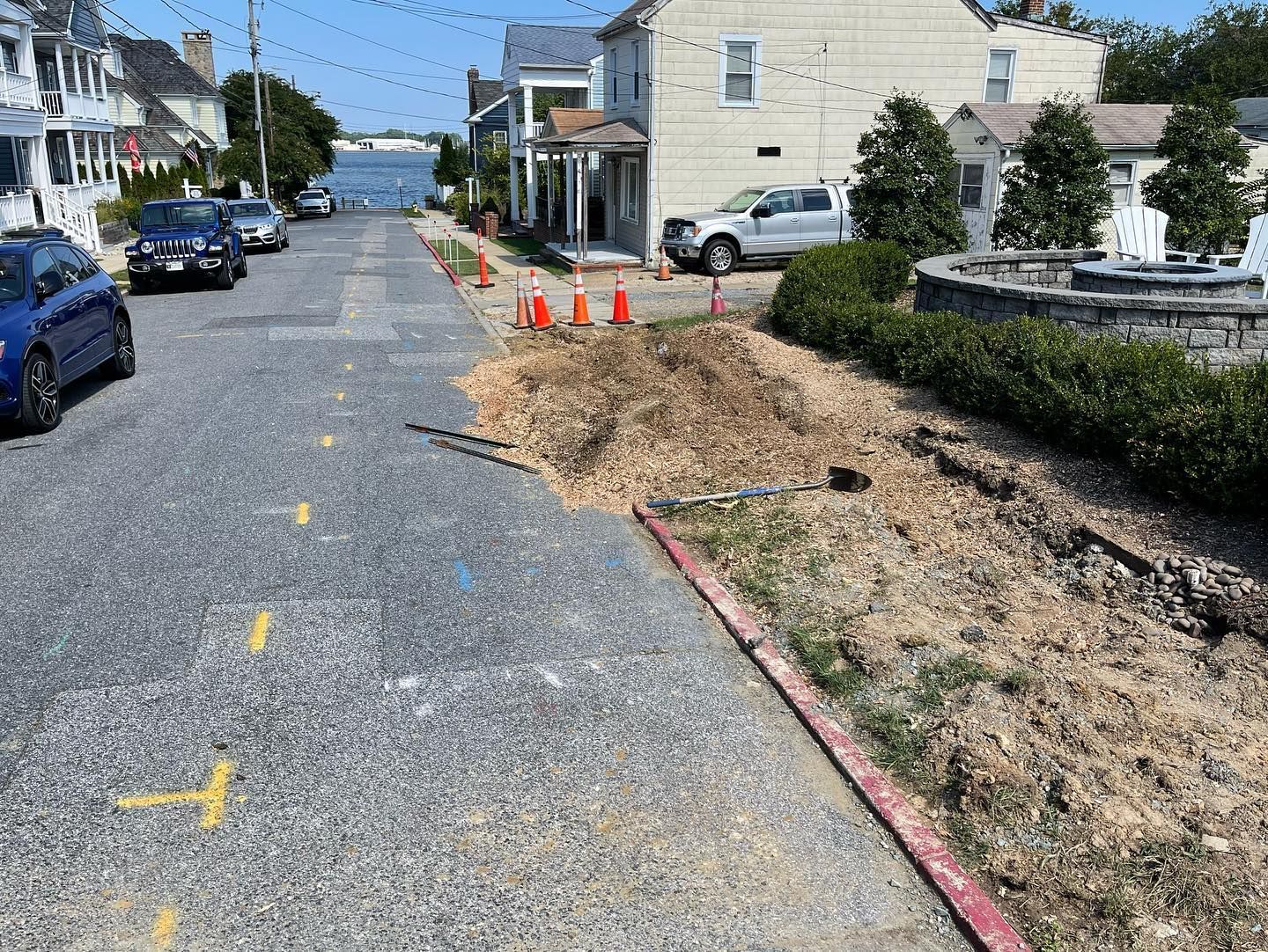 A street with cars parked on the side of it and a pile of dirt on the side of the road.