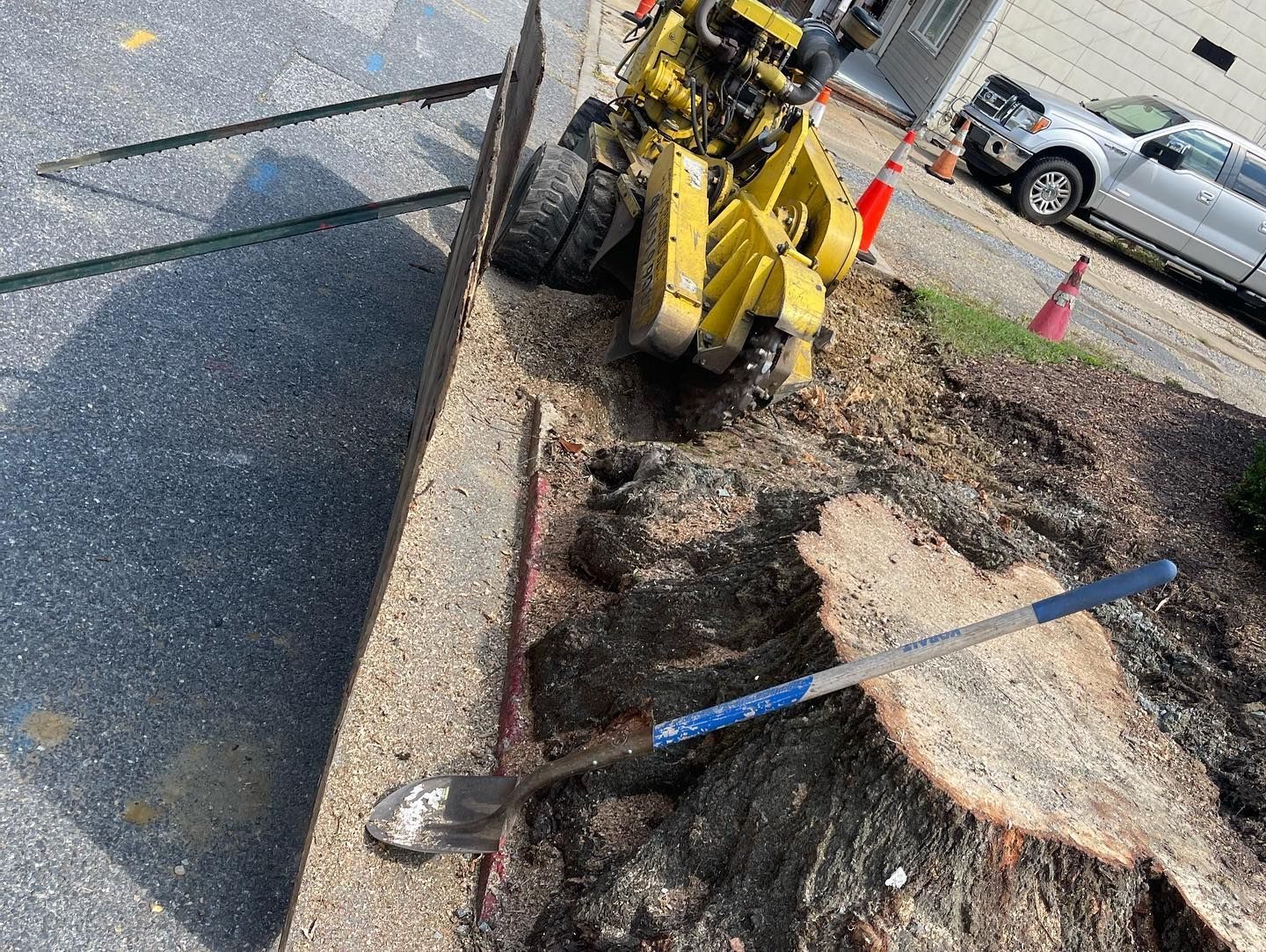A large tree stump is being removed by a machine.