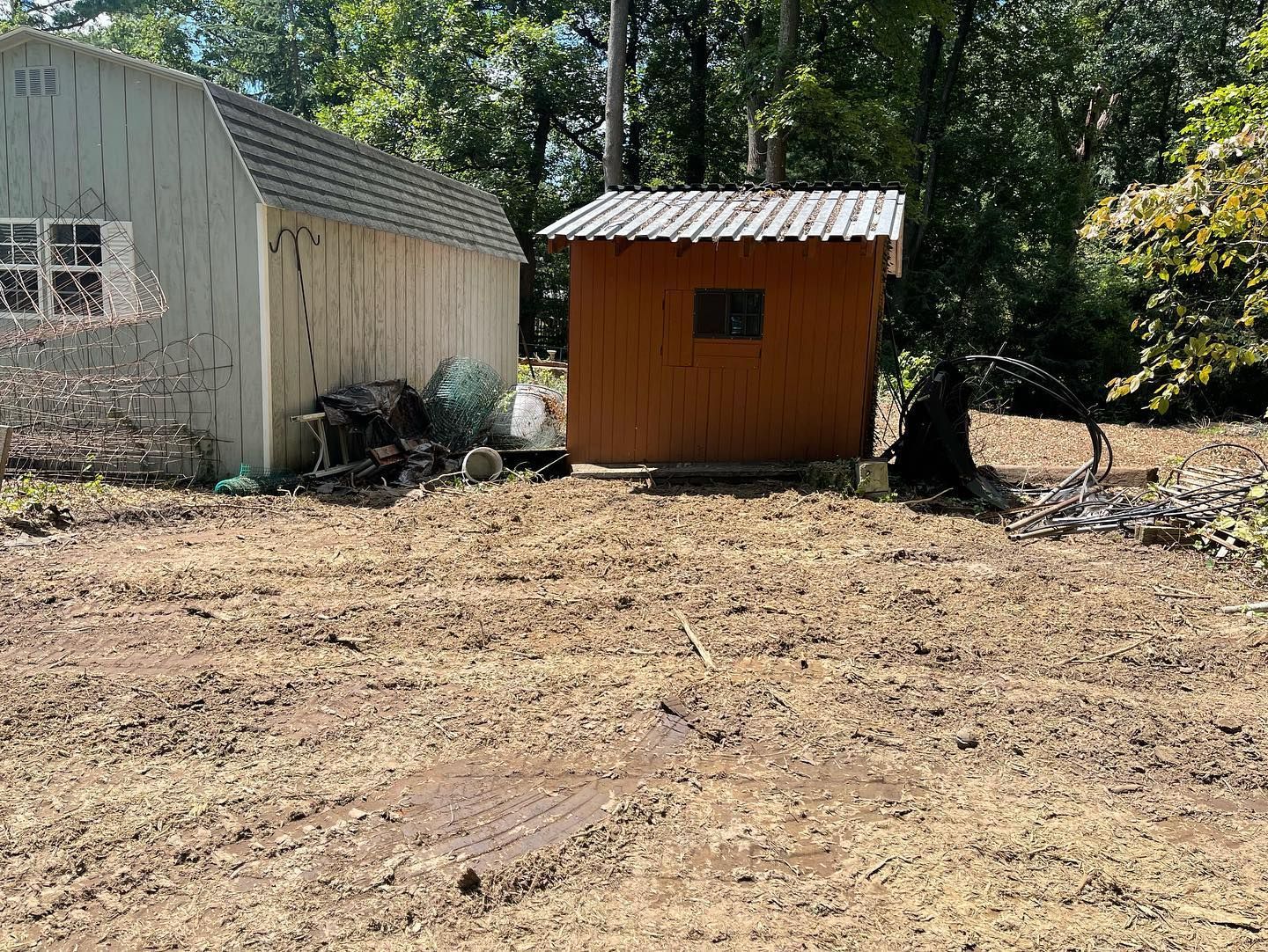 There is a shed in the middle of a dirt field.