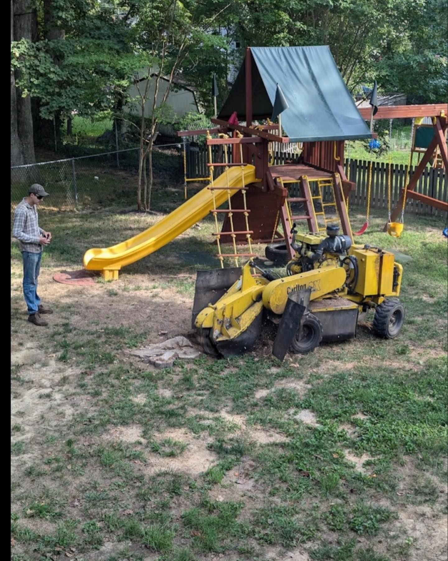 A man stands in front of a playground with a yellow slide