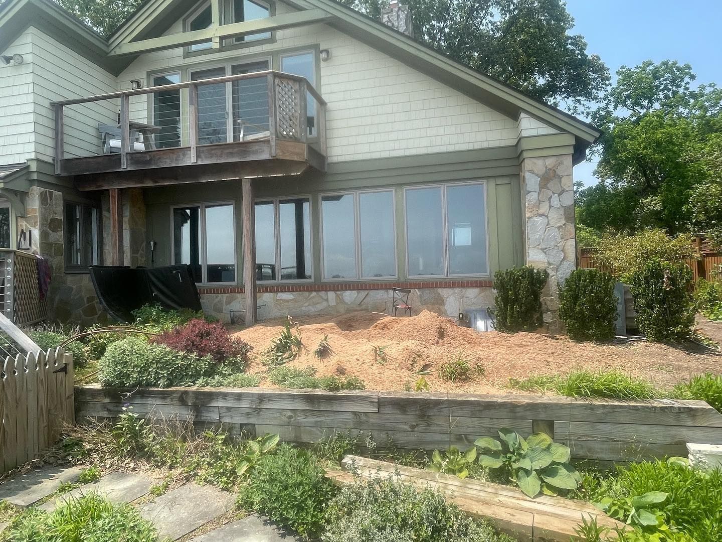 A large house with a lot of windows is sitting on top of a hill.
