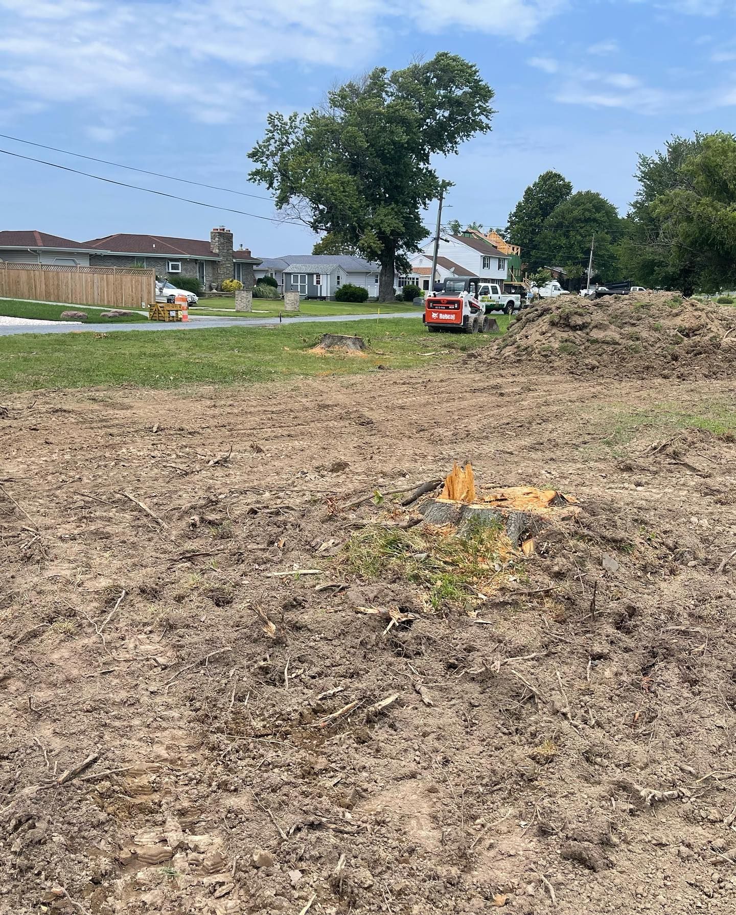 A dirt field with a red car parked in the background.