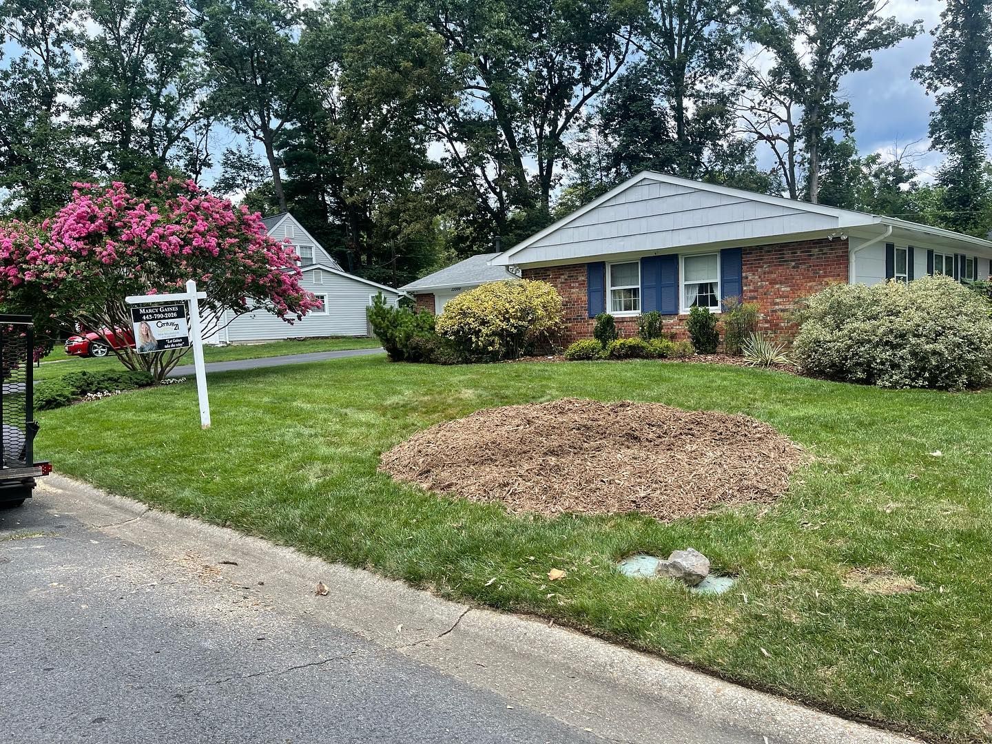 A house with a lot of grass and trees in front of it.
