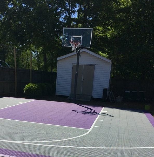 A basketball court with a white shed in the background