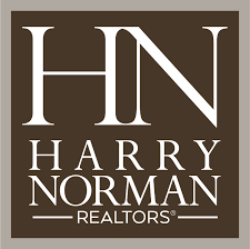 The logo for harry norman realtors is brown and white