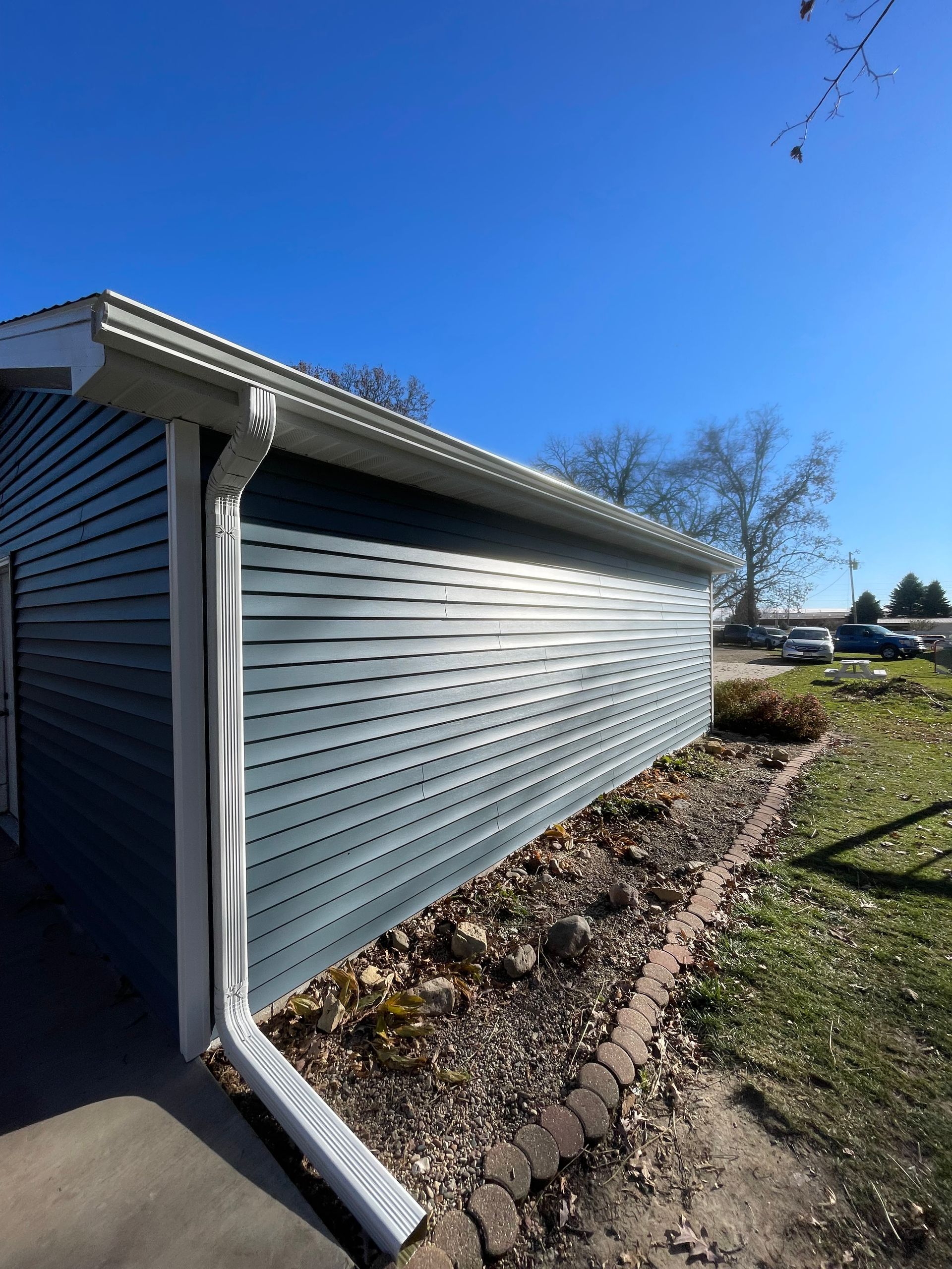 A house with a blue siding and a white gutter