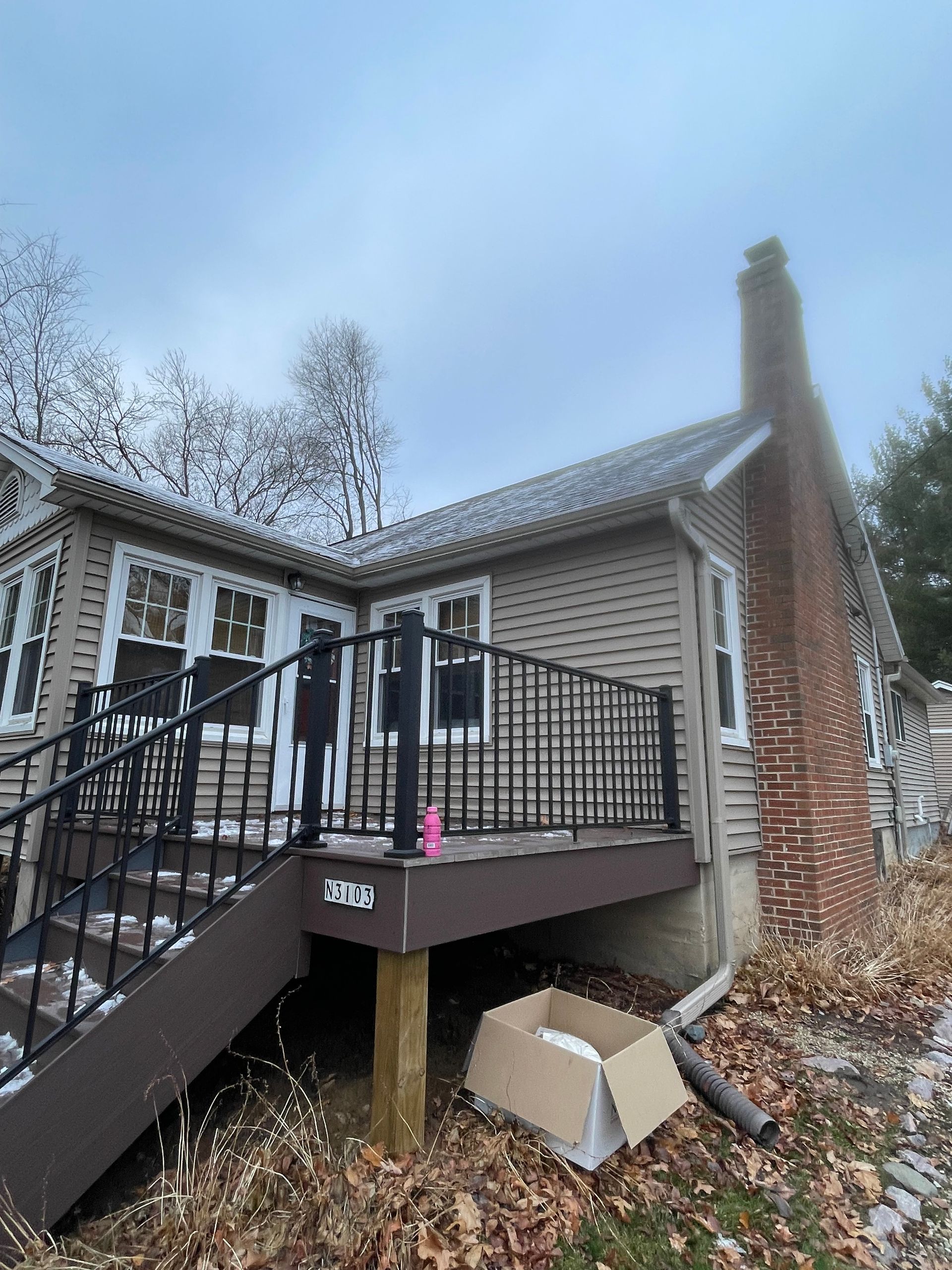 A house with a deck and stairs in front of it.