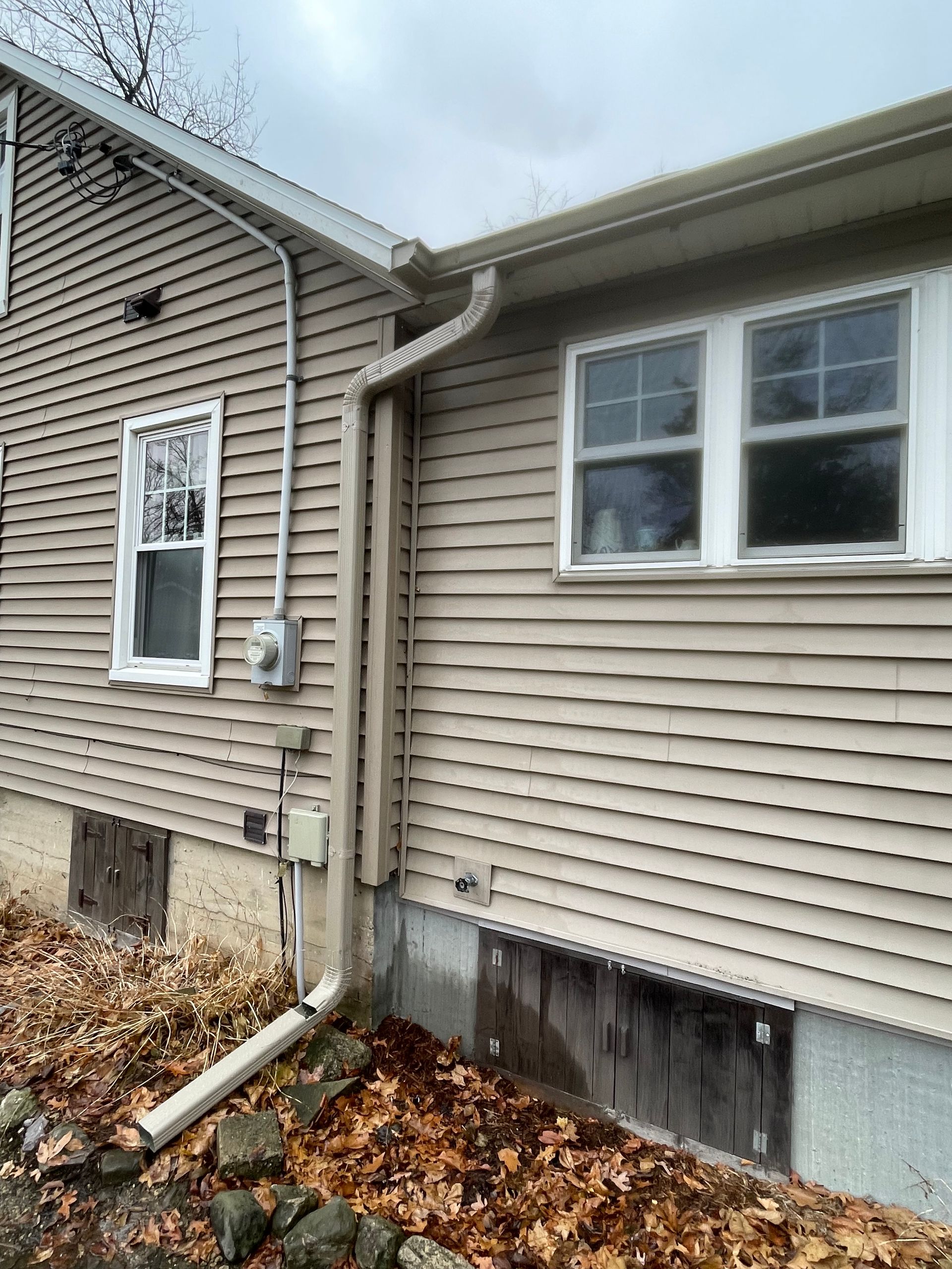 A house with a lot of windows and a gutter on the side of it.