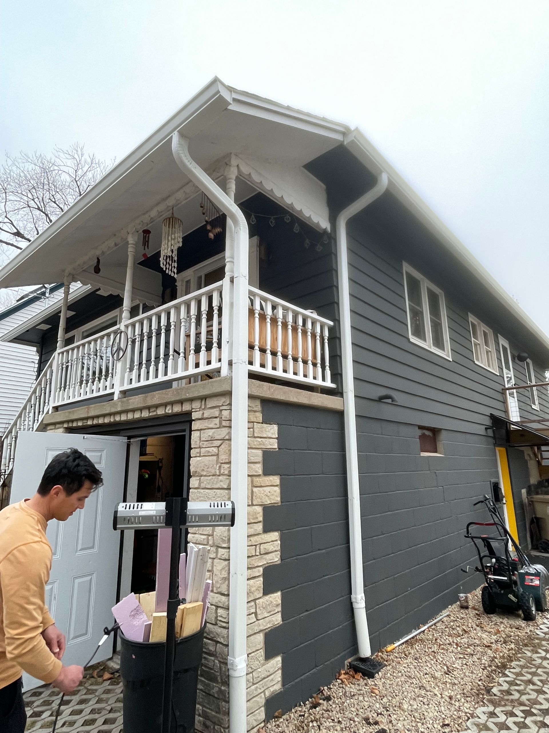 A man is standing in front of a house with a balcony