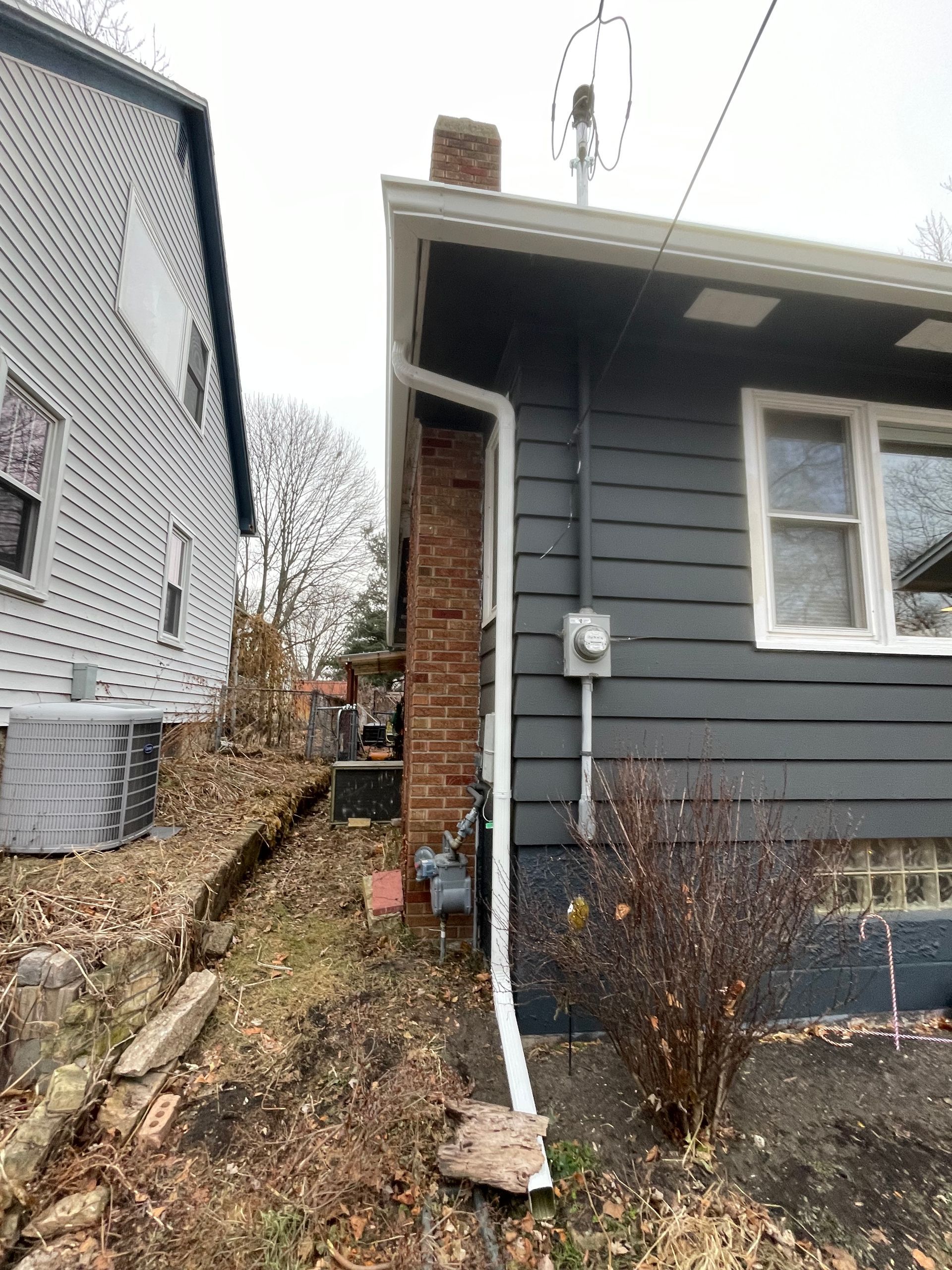 A house with a gutter on the side of it and a chimney.