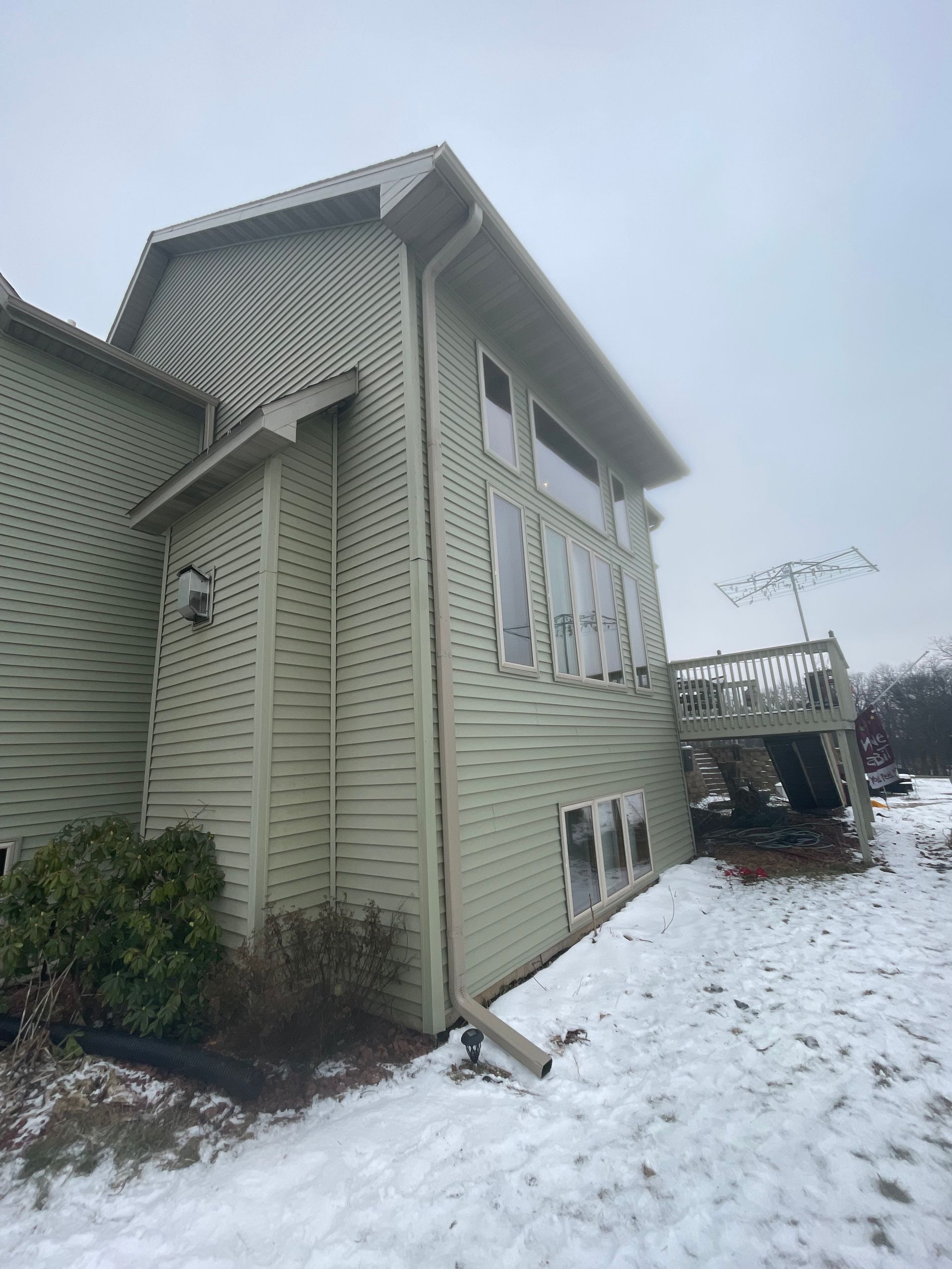 A large house with a lot of windows is covered in snow.