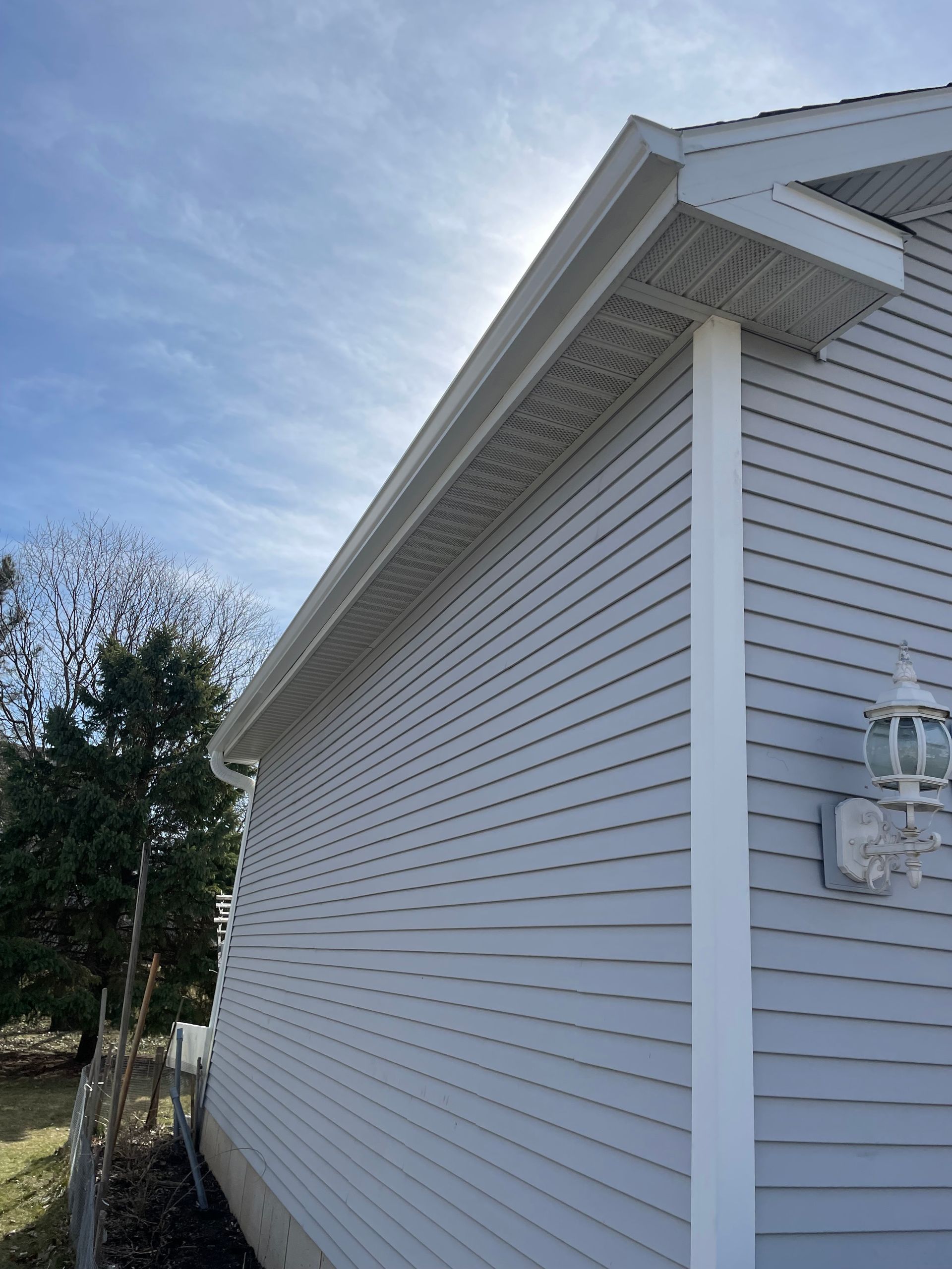 A white house with a light on the side of it.