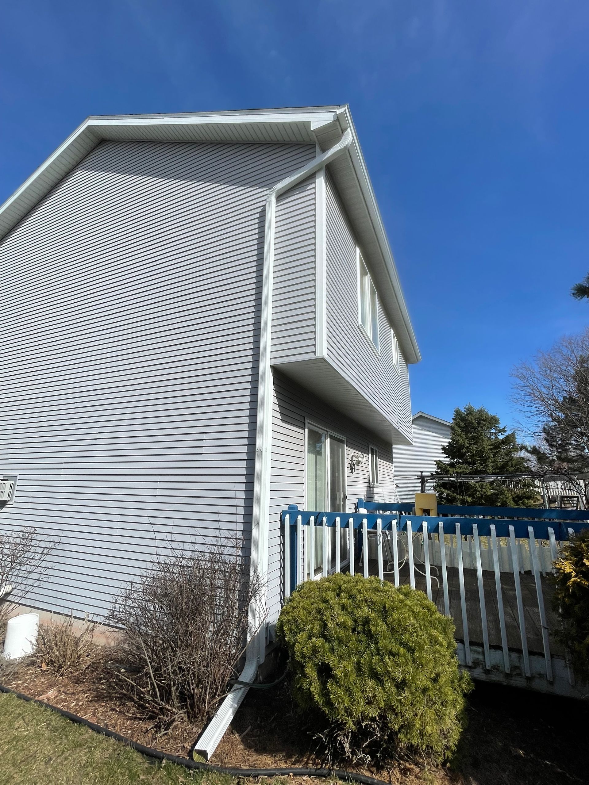 A white house with a blue fence in front of it