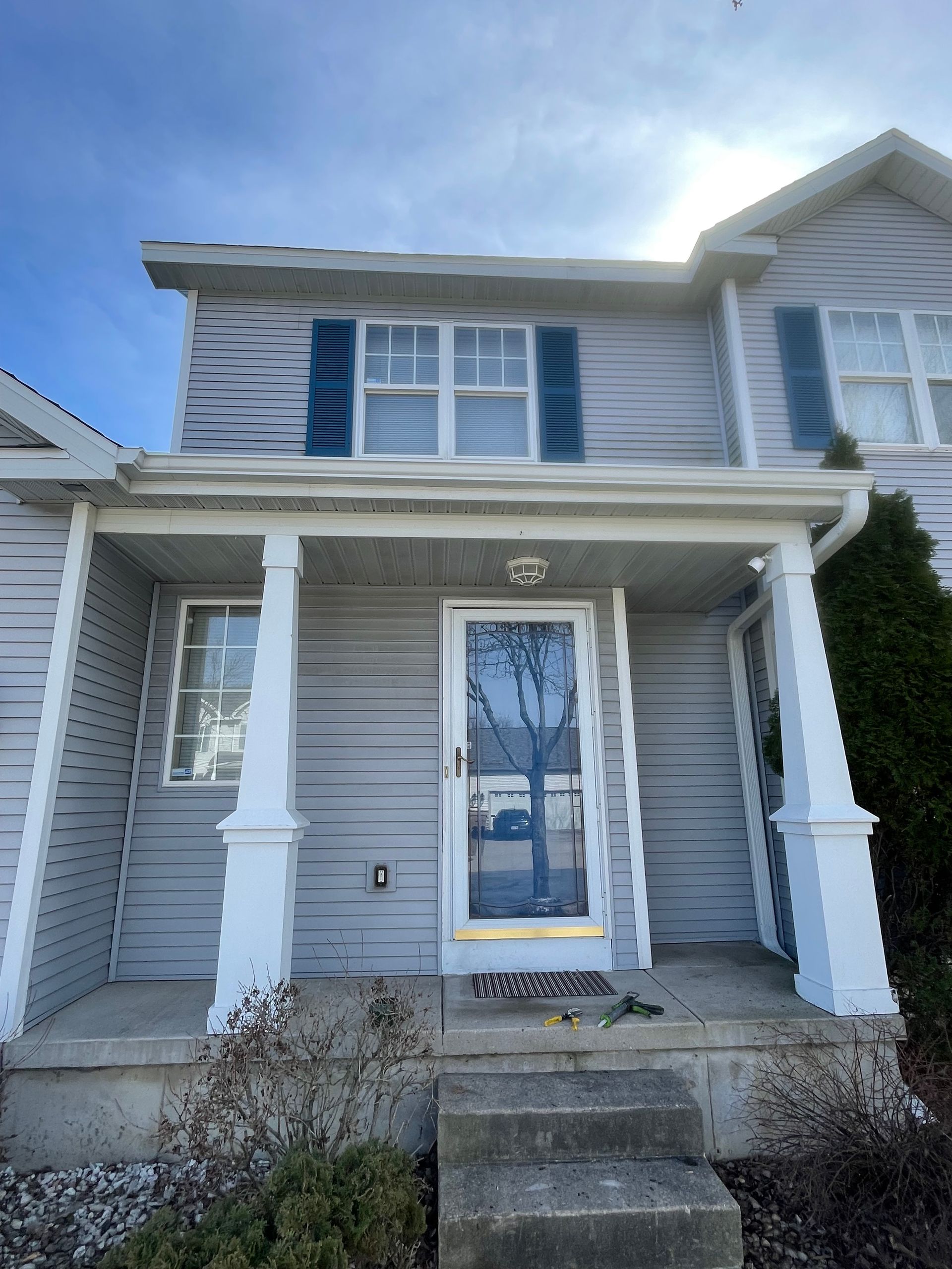 The front of a house with a porch and stairs.