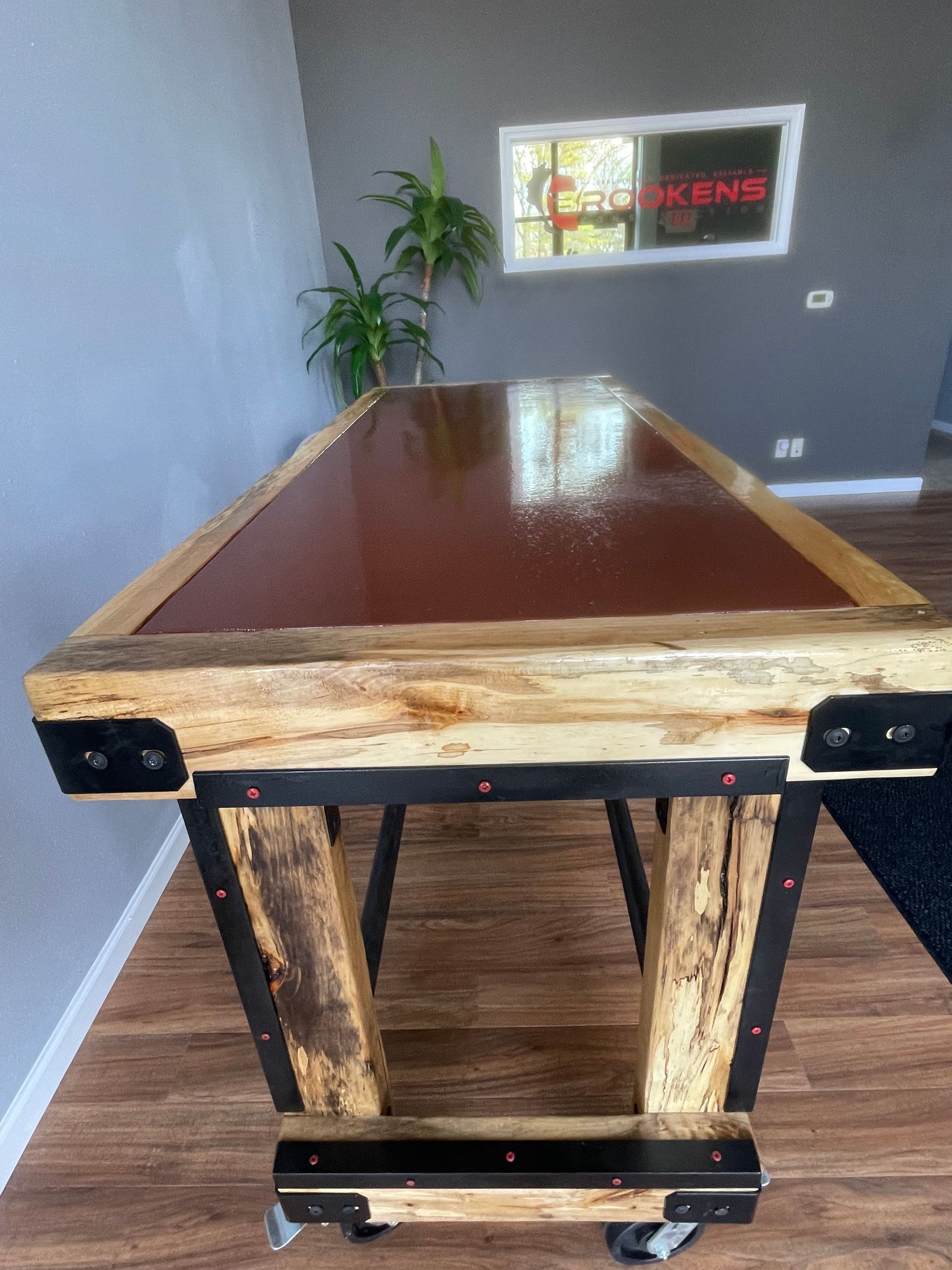 A wooden table with a red top is in a room