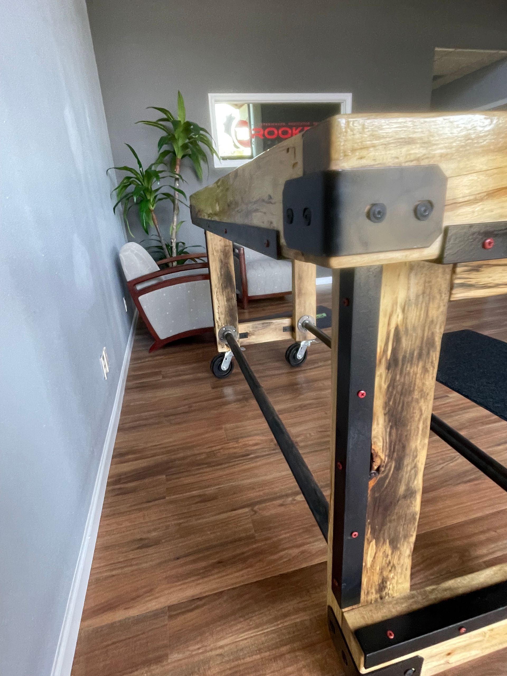 A wooden table with wheels is in a living room.