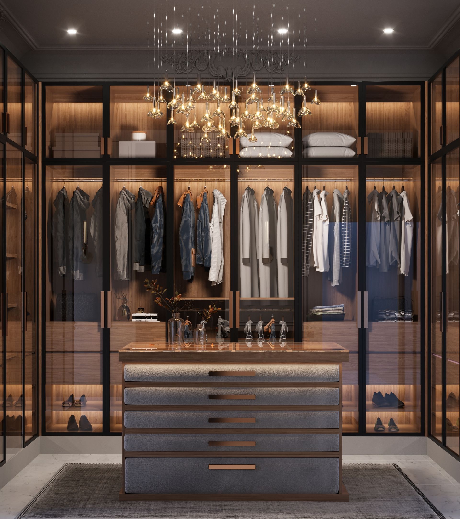 Walk-in closet with wood and glass cabinets, clothes hanging, island drawers, and chandelier.