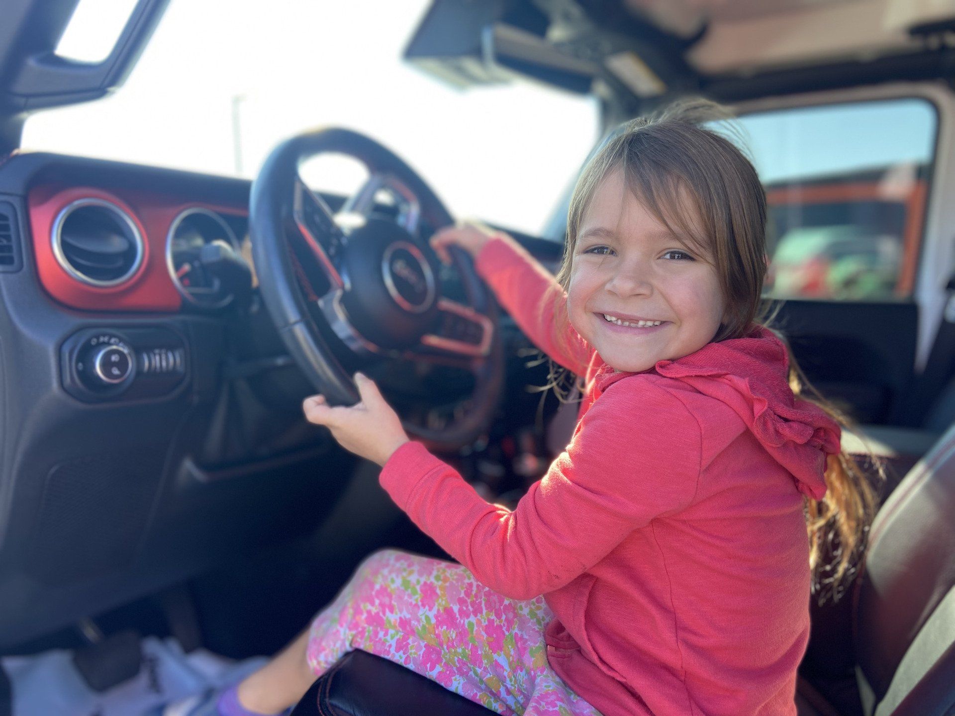 young girl in front seat of jeep