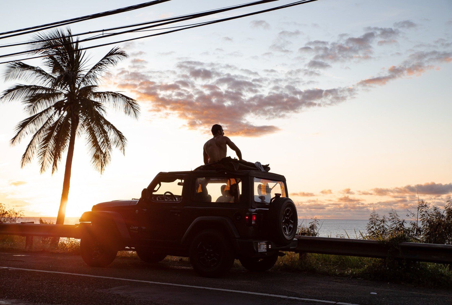 A man sitting on the top of the jeep wrangler