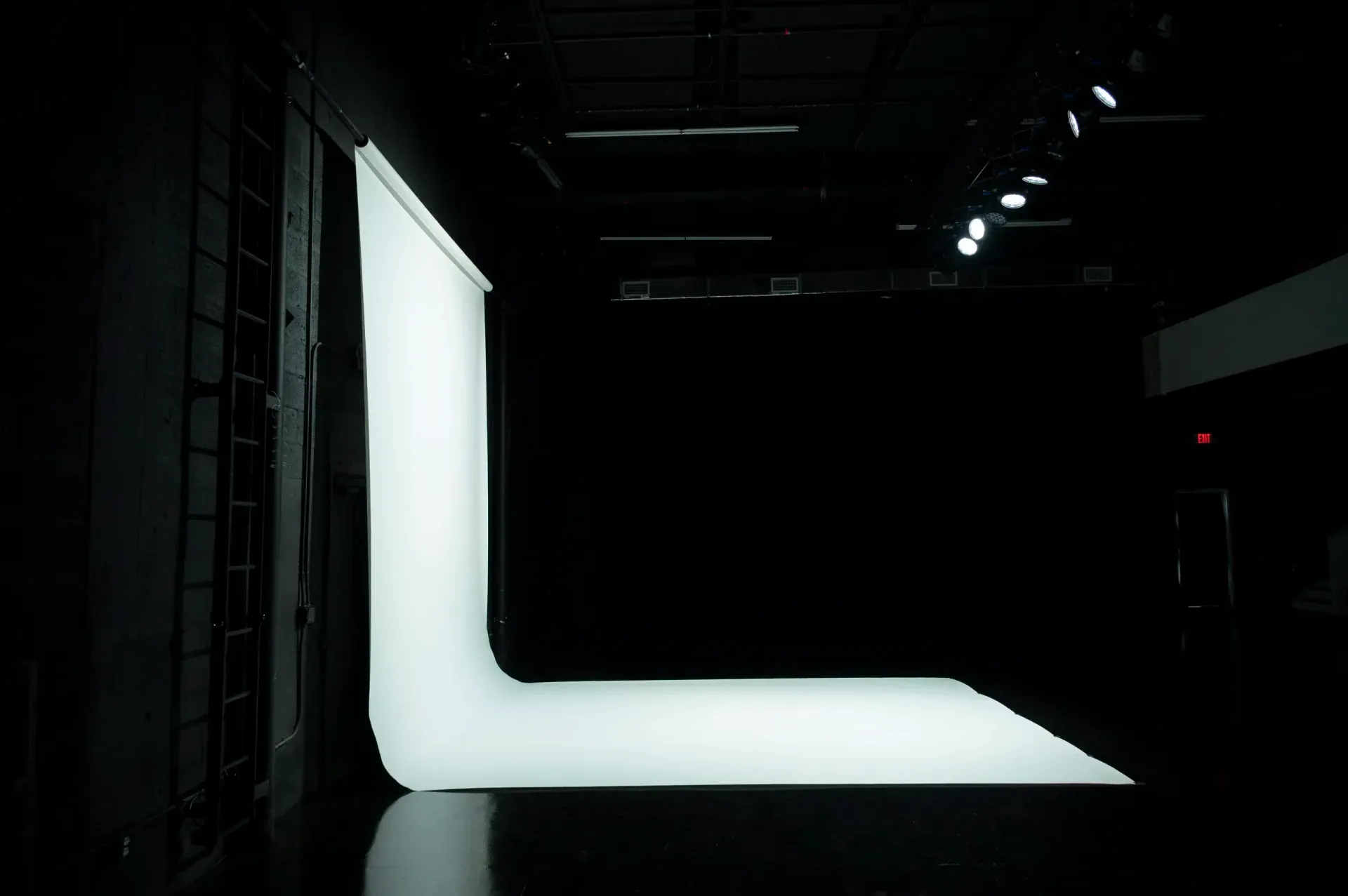 L-shaped white backdrop in a dark studio.