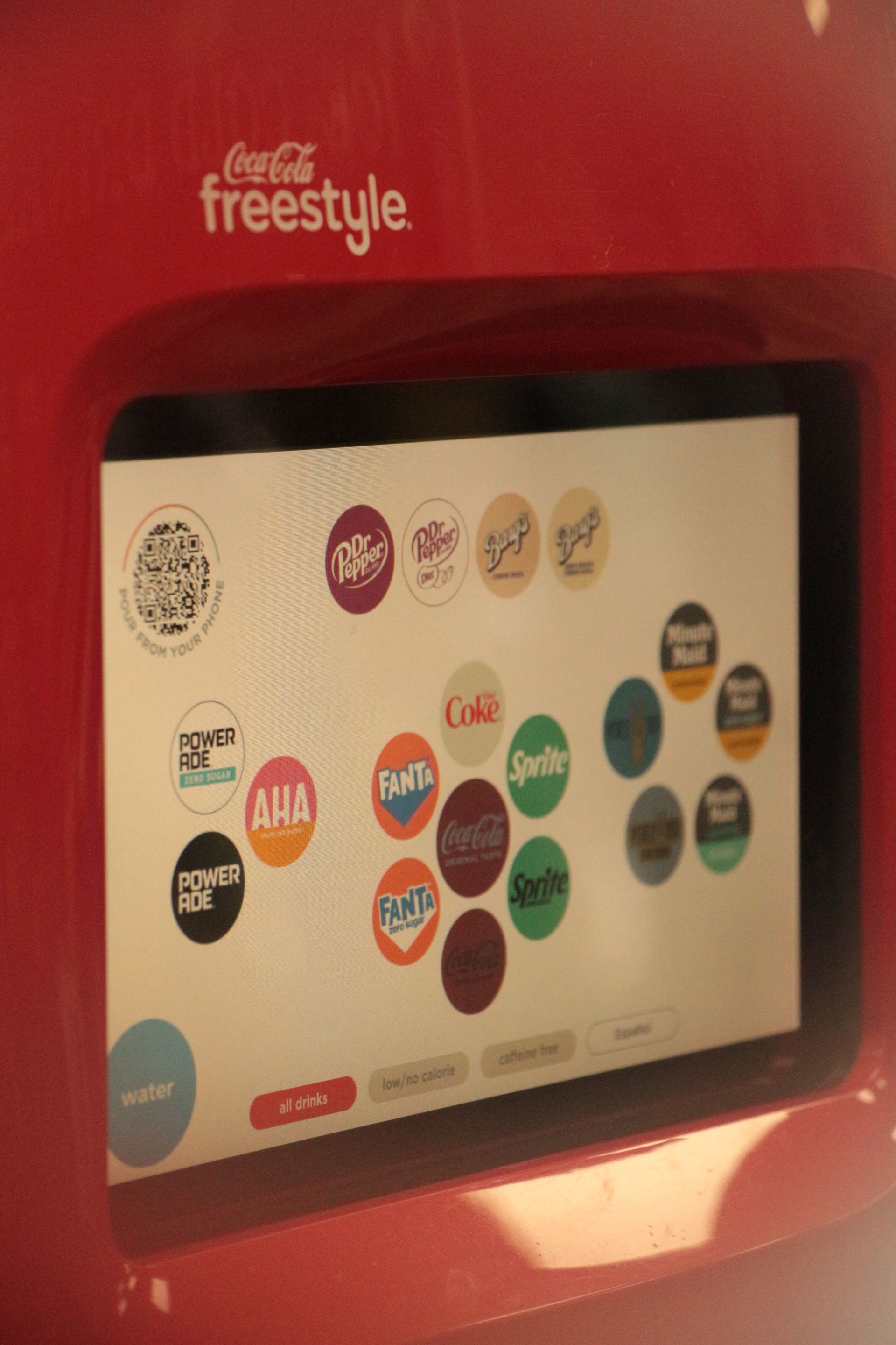 Shelves in a convenience store filled with various candy and snacks, a restroom sign is visible.