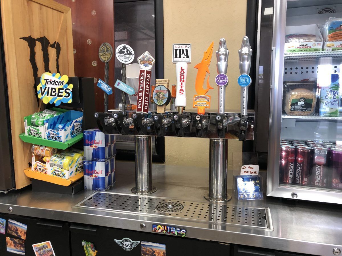 Bar with beer taps, energy drinks, snacks, and a refrigerated display case.
