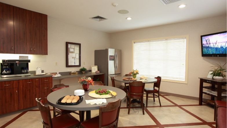 A kitchen with tables and chairs and a flat screen tv