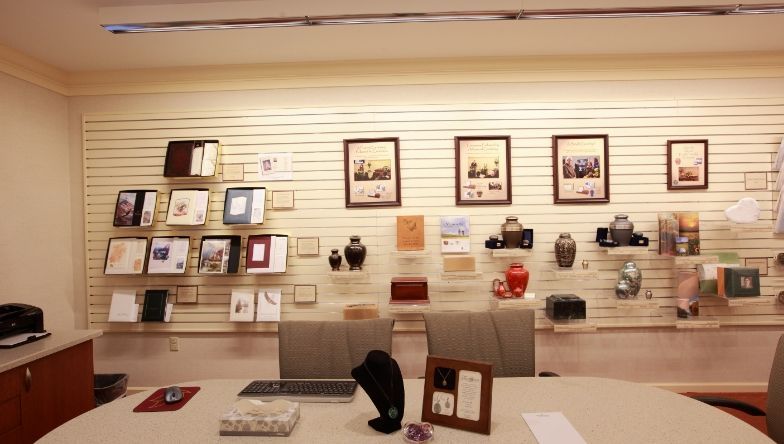 A room with a table and chairs and a wall with pictures on it