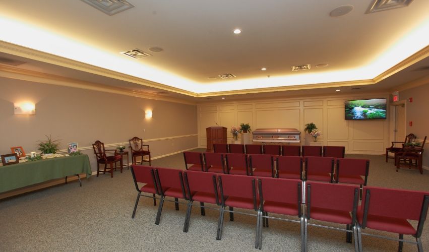 A large room with red chairs and a television on the wall.