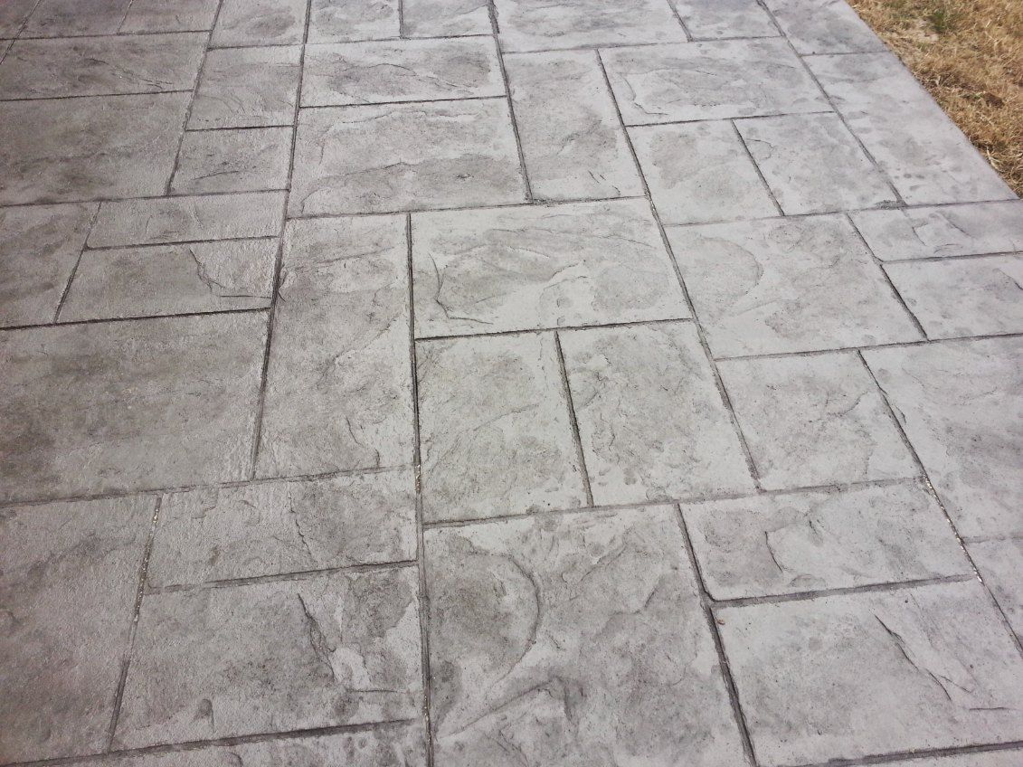 A concrete walkway with a pattern of squares on it