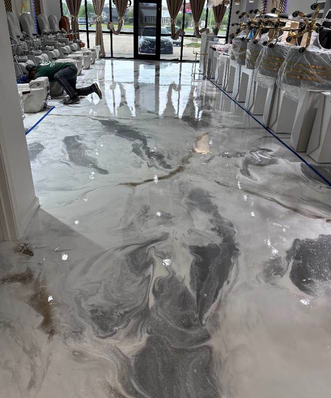 A man is kneeling on a marble floor in a bathroom.