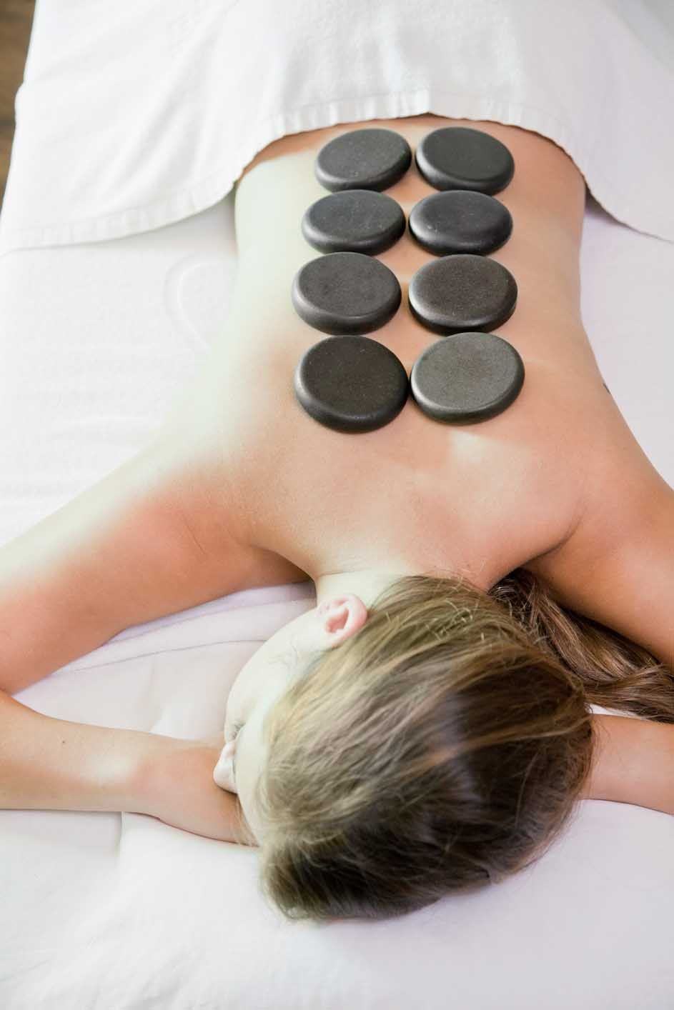 Woman Getting a Massage with Hot Stones on Her Back — Miami, FL — Massage & Oriental Spa