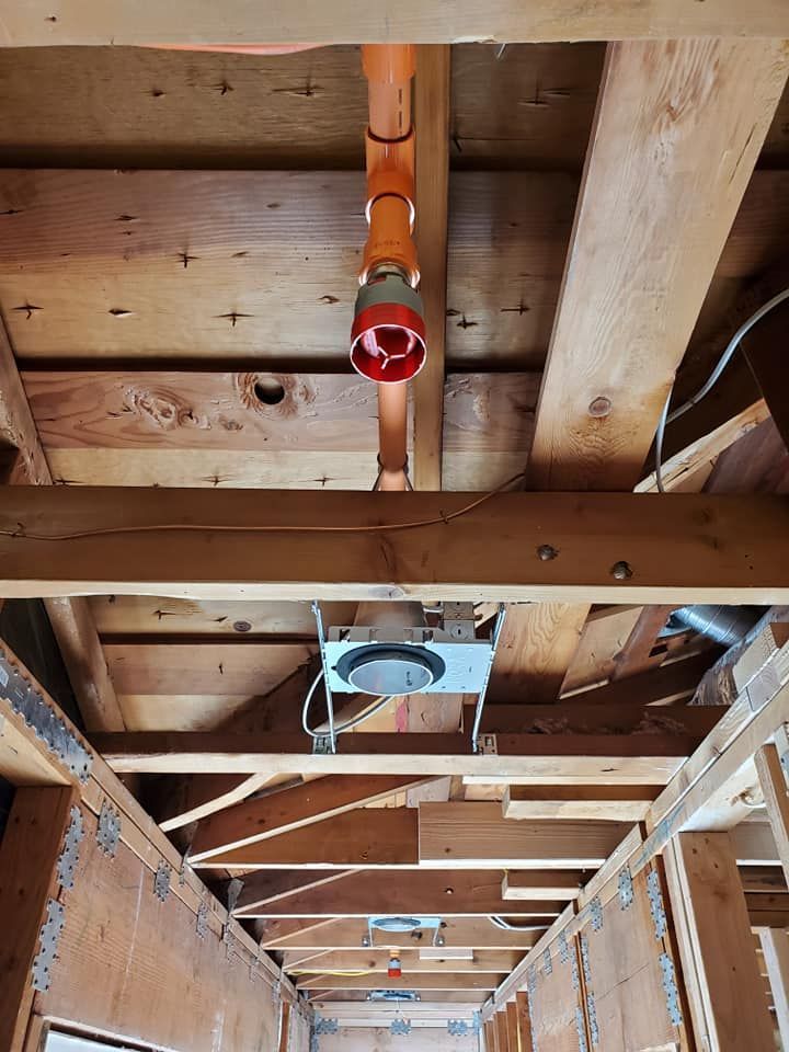 A wooden ceiling with a red pipe hanging from it.