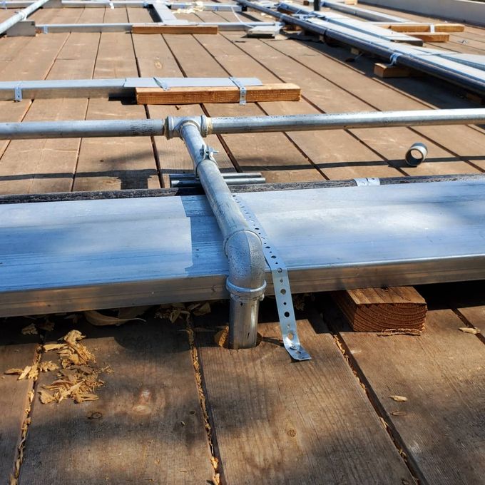 A wooden deck with metal pipes attached to it