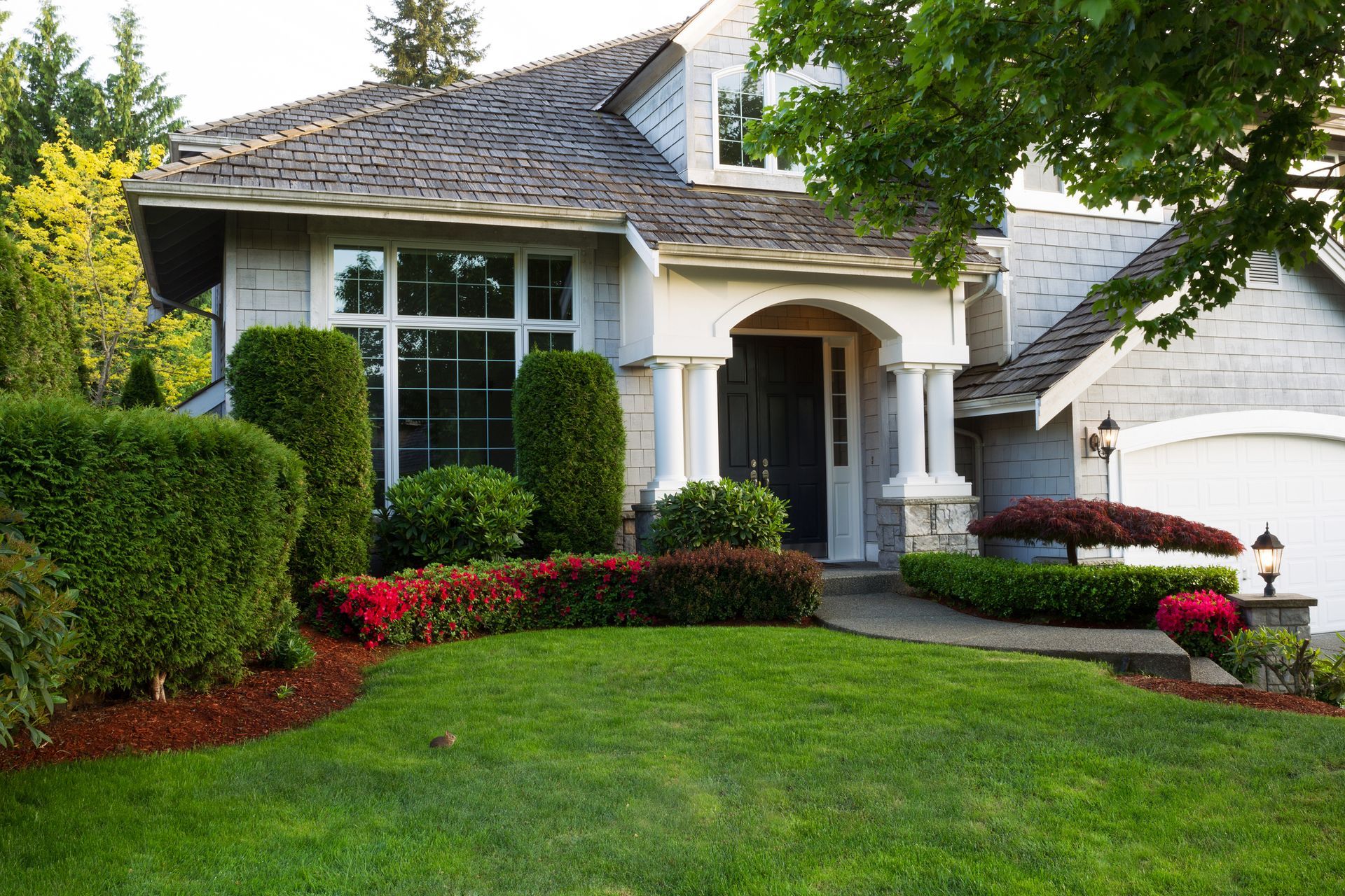 A large house with a lush green lawn in front of it.