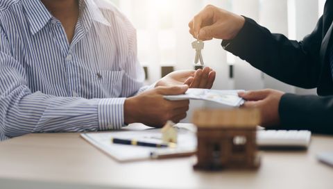 leasing agent passing over home keys to a new tenant