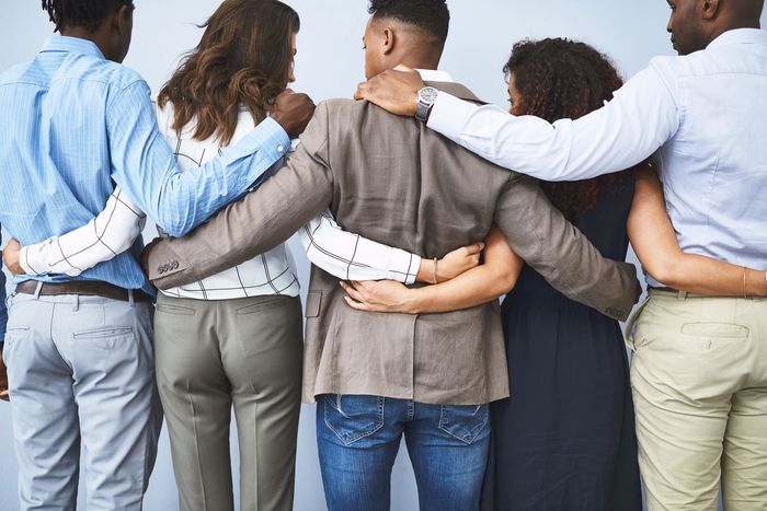 group photo of a team of managers hugging from behind