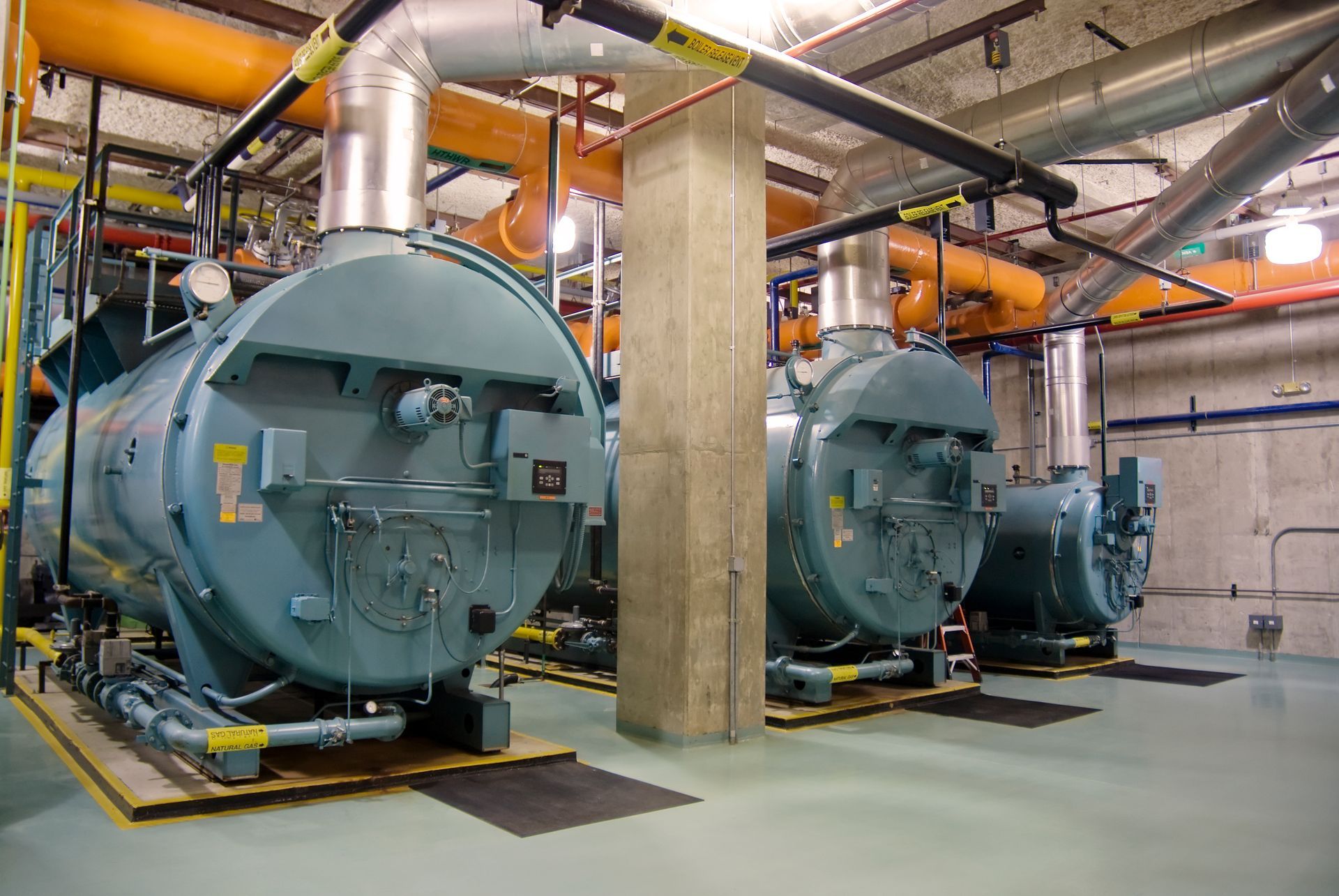 Industrial boilers supply facility with large steam boiler units in factory.