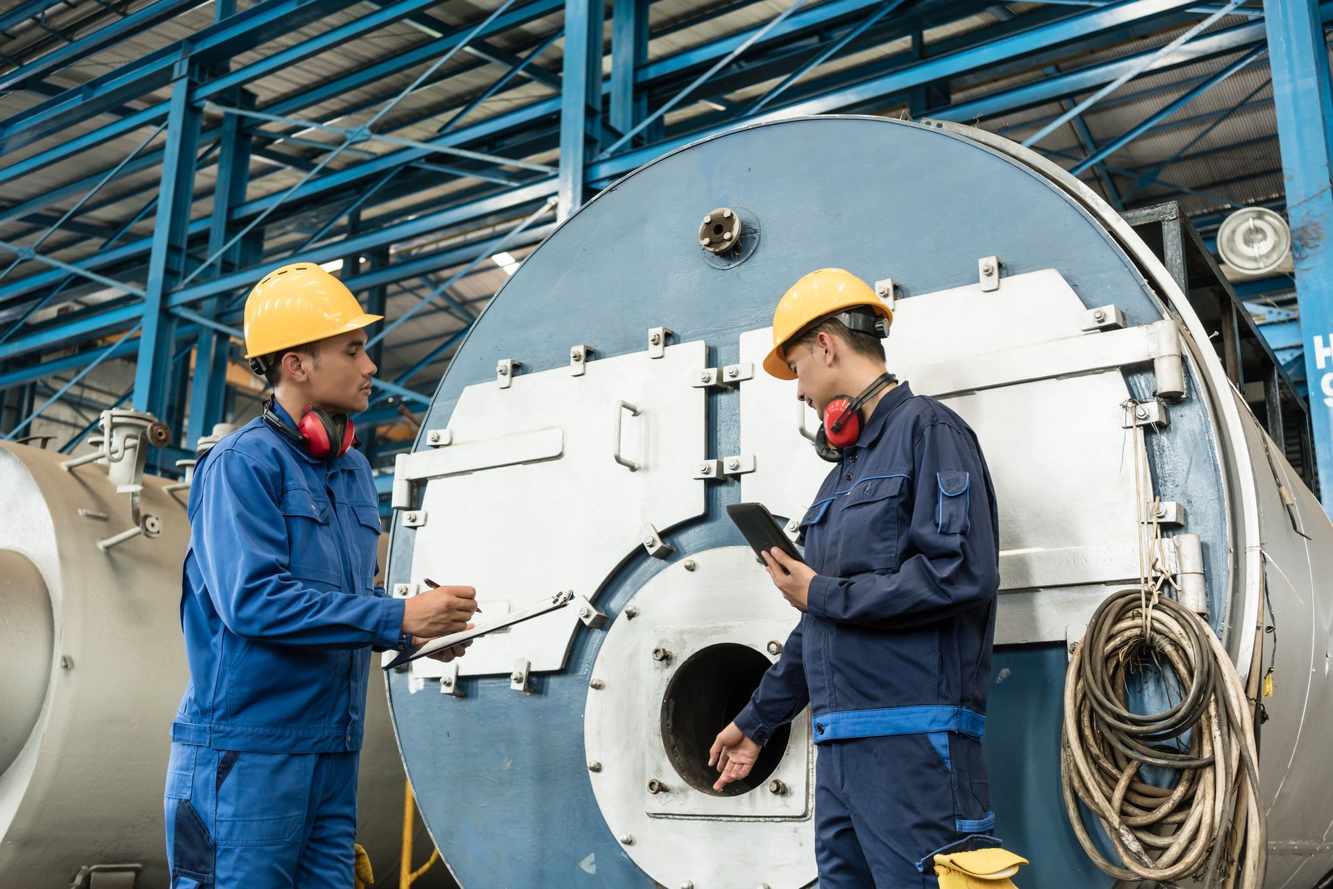 Two experts checking the quality of an industrial boiler.