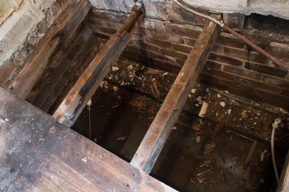a hole in a brick wall with wooden beams .