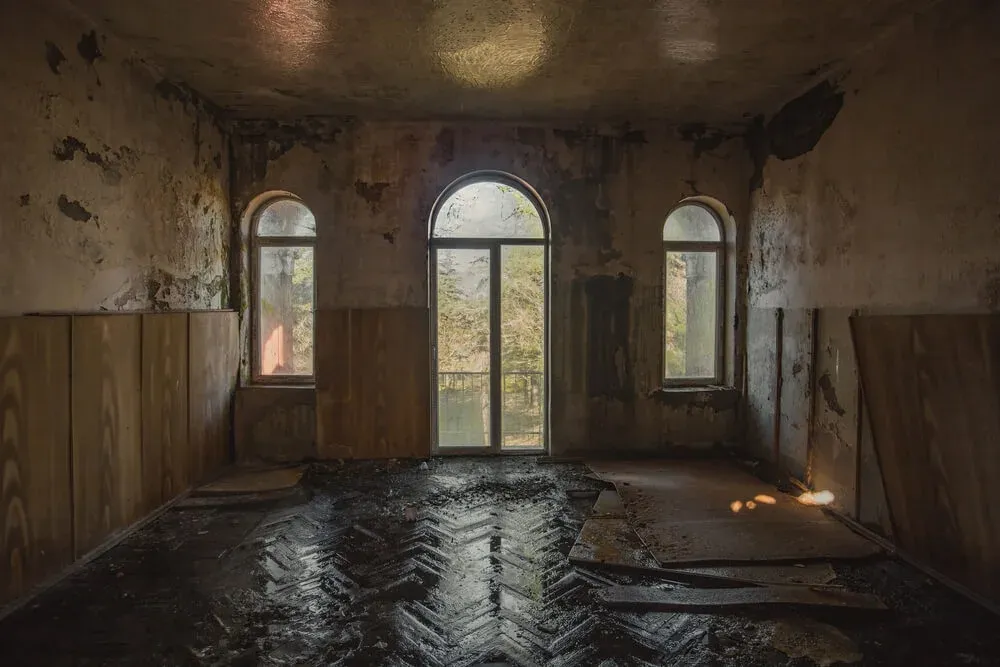 a room with a lot of windows and a 
flooded floor in an abandoned building .
