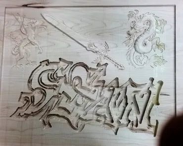 A laser-etched wooden panel featuring a stylized graffiti name, a longsword, a winged creature, and a coiled dragon.