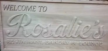 A light wood sign with carved text reading