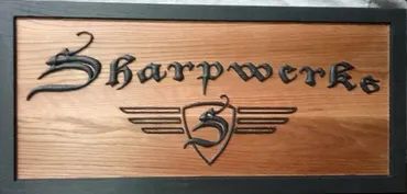 A rectangular wooden sign framed in black with the text