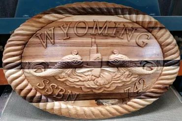 A carved wooden oval plaque featuring