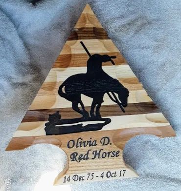 Arrowhead-shaped wooden plaque with a black horse silhouette, inscribed