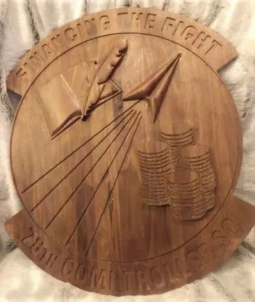 A wooden carved emblem reading