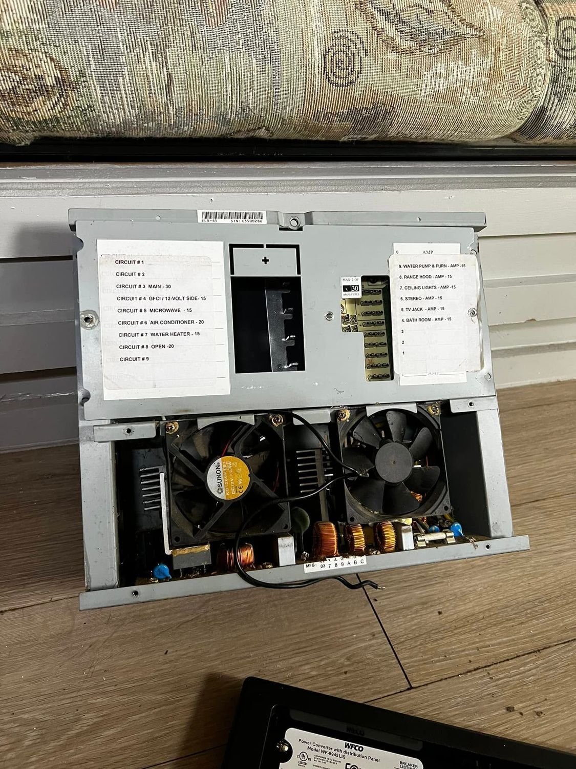 Opened computer power supply with fans, circuitry, and papers.