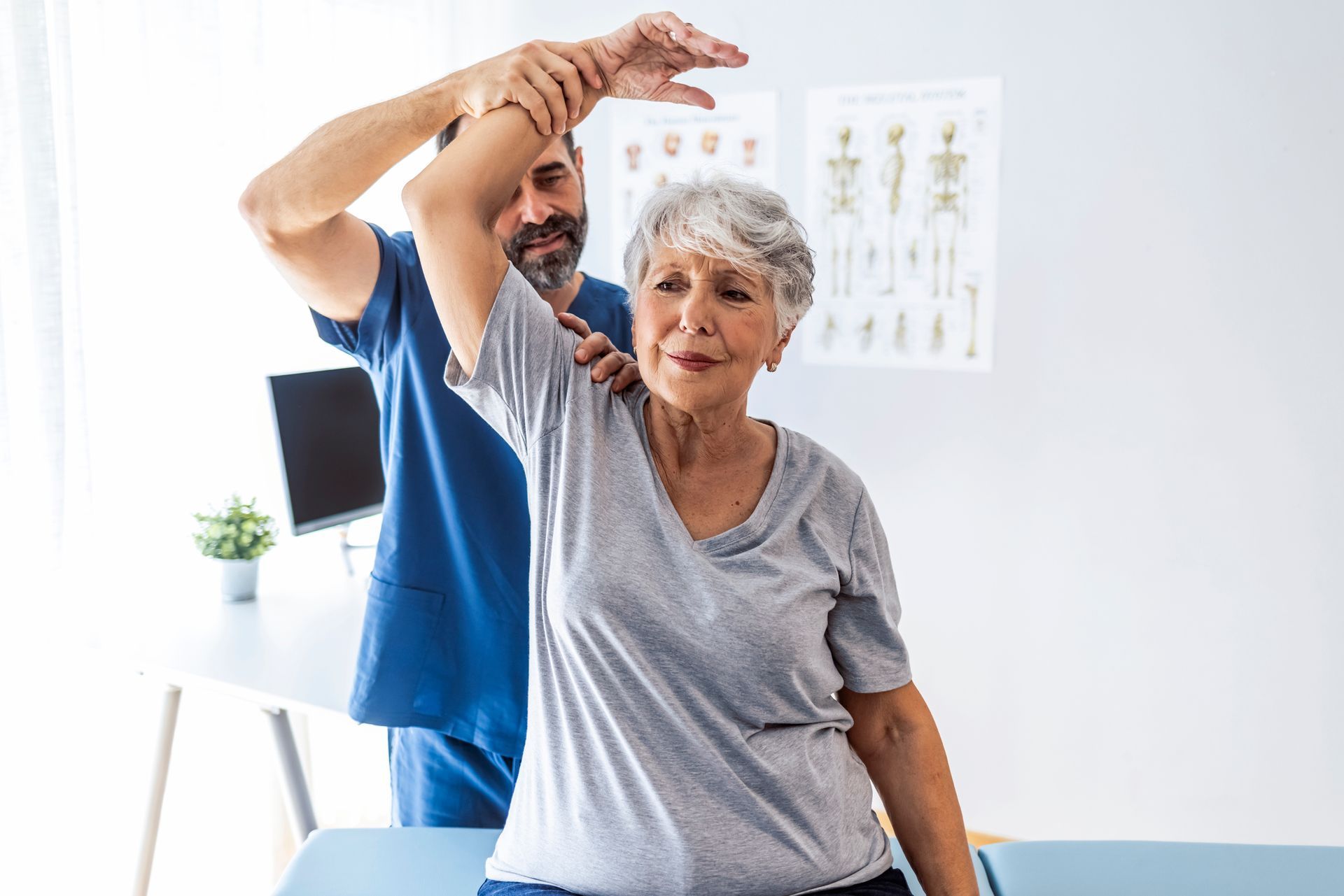 A man is helping an elderly woman stretch her arms. A man is helping an elderly woman stretch her arms.