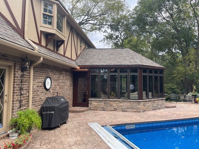A large house with a swimming pool in front of it.